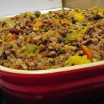 red casserole dish filled with wild rice and various roasted vegetables