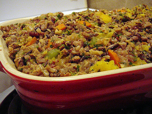 red casserole dish filled with wild rice and various roasted vegetables